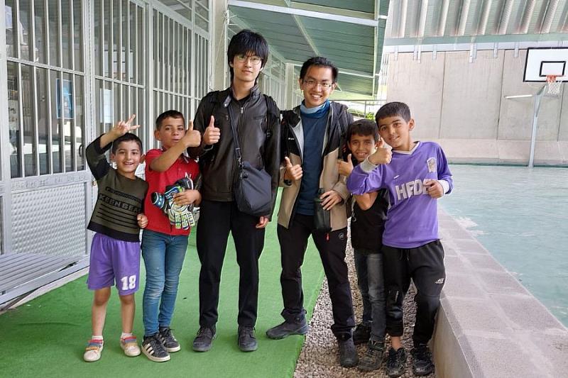 建築專業學院學士班王承恩(左４)與黃弘量(左3)與當地敘利亞兒童相處融洽，平時一同運動，分享文化與甜點。