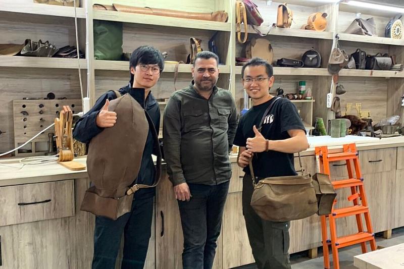 二位逢甲同學與台灣中心內的皮革匠人—瓦達以及他的作品合照。