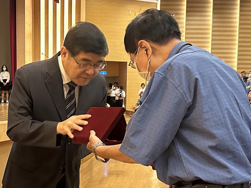 高雄醫學大學校長楊俊毓(左)代表學校致贈感謝牌給大體老師、器官捐贈及病理解剖老師的家屬
