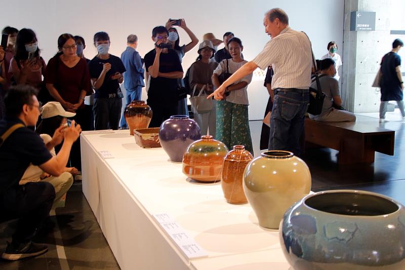 參展陶藝家薛瑞芳為民眾導覽，欣賞釉色多變、質感各異的灰釉陶藝作品。