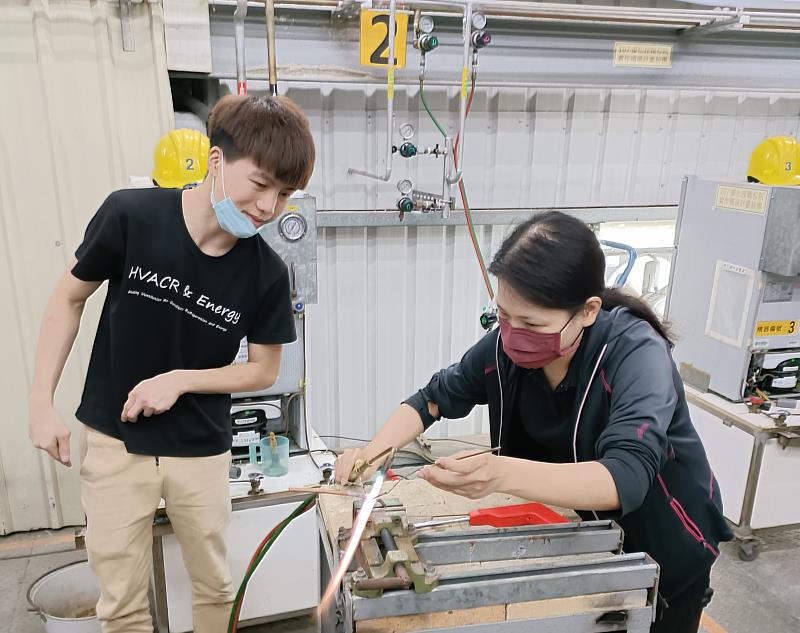 圖說：郭鎧瑋（左）指導業界學員進行氧乙炔焊接練習。（圖/中信科技大學提供）