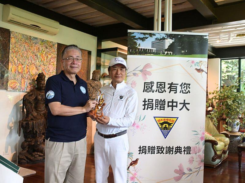 中央大學周景揚校長（左）致贈琉璃給點將家投資股份有限公司陳景松董事長（右），感謝他對極地研究的大力支持。