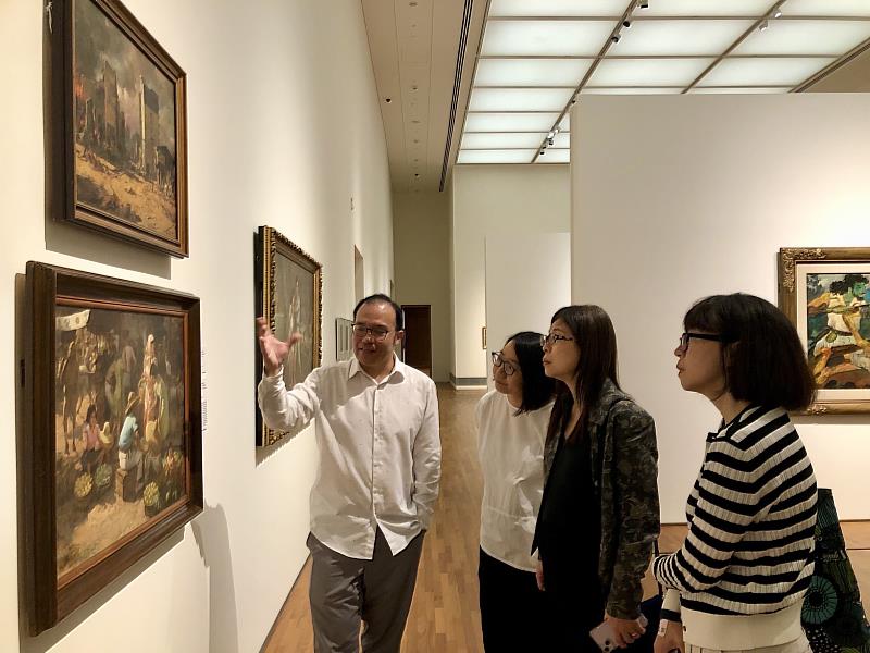 新加坡國家美術館資深策展人辛友仁（左1）為國美館館長陳貺怡（右2）一行解說作品情形