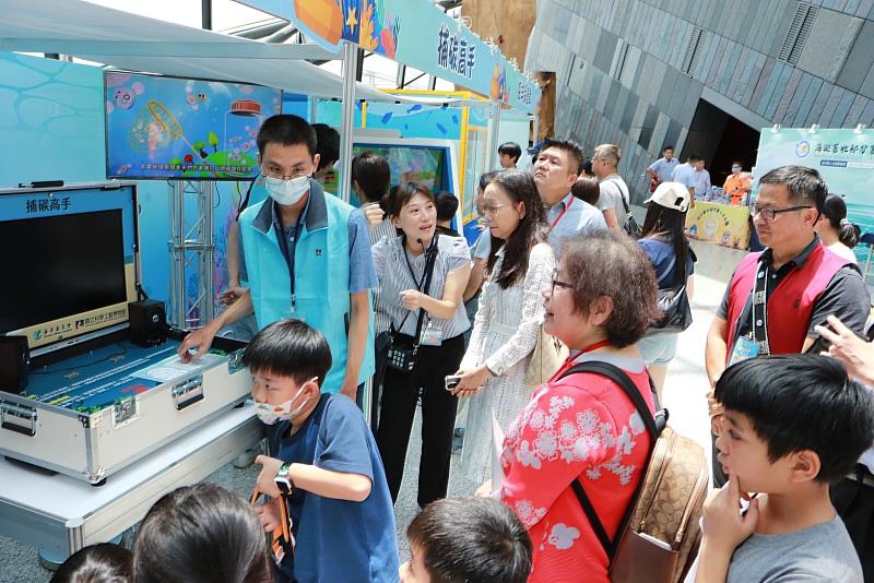 海委會黃政務副主委、科工館李館長、蘭博館陳館長與現場小朋友共同參觀海洋教育攤位