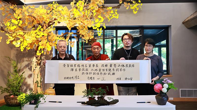 （左起）陳玉峯教授、心道法師、愛智圖書代表楊慕熙、楊喬銥在贈書卷軸上落款後合影紀念。（靈鷲山佛教教團提供）