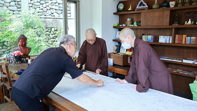 陳玉峯教授向靈鷲山法師們展示過去研究玉山植物時的珍貴紀錄史料。（靈鷲山佛教教團提供）