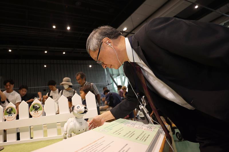 日本科學未來館「你好！機器人」展，適合大人陪伴小孩參觀，文化部長李遠與展場中的機器寵物互動。