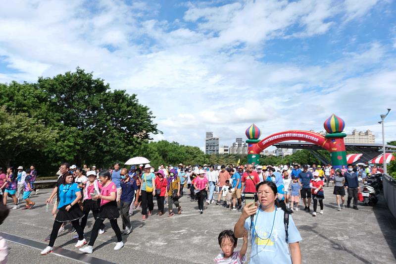 官網-大朋友、小朋友身著運動服，繞著體育場共同完成健走