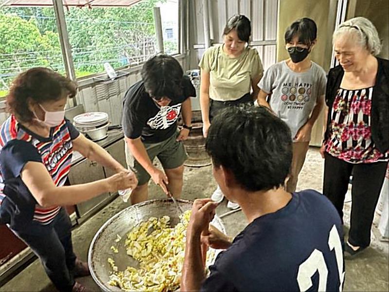 長輩指導青年如何用大炒鍋料理。