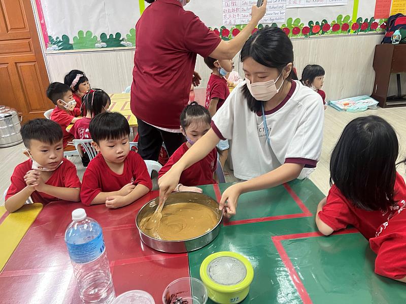 亞大幼教系簡子寧同學，在馬來西亞實習時帶領幼兒製作黑糖糕。