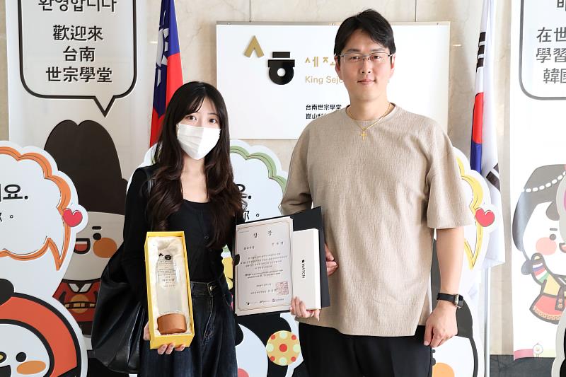台南世宗學堂營運長暨語言中心主任高濟庚(右)頒發獎盃與獎品予設計組第二名陳郁馨(左)