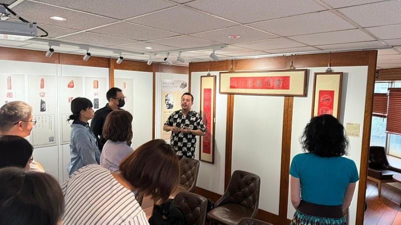 「墨跡與方寸之間」展覽導覽中，解說林語堂的印章與書法藝術，吸引觀眾專注聆聽。