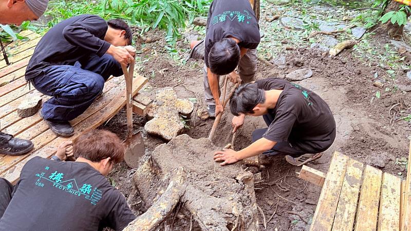 淡江建築系學生團隊「淡江構築」成員，神速移除了碩大而頑強的樹頭，搶救彩虹橋。（圖／淡江大學提供）