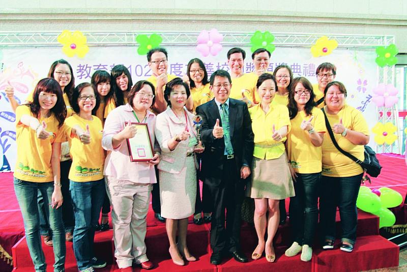 淡江大學榮獲教育部「102年度友善校園獎」,是當年入選「卓越學校」唯一的大專校院,學務處專員陳瑞娥(左3)亦獲傑出學務人員獎;時任教育部部長蔣偉寧(右4)與時任該校校長張家宜(左4)及同仁開心合影。(圖/淡江大學提供)