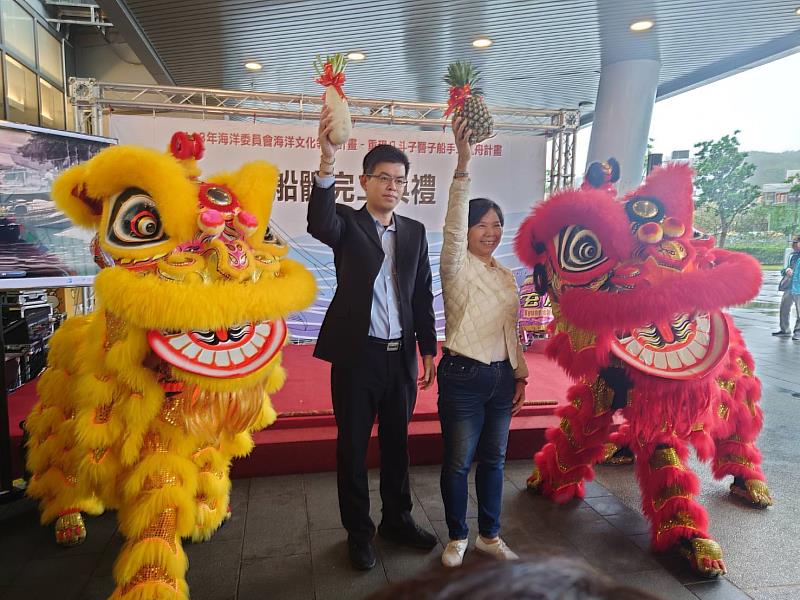 海洋委員會羅斯平科長及國立海洋科技博物館陳素芬館長從舞獅口中接過「菜頭」與「旺來」