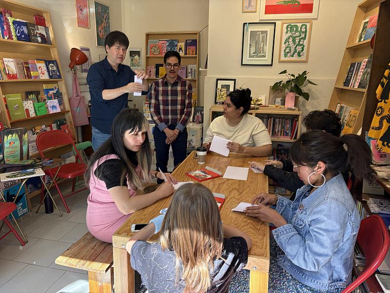 劉旭恭在La Fiera書店進行工作坊，引導參加者運用日、月、星、雨四個意象，創作一本小書。（圖／文策院）