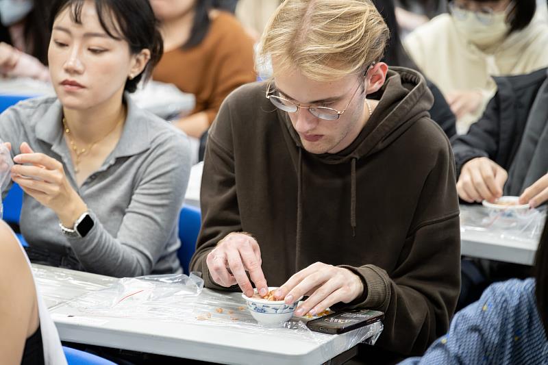 來自德國的交換生Julien，認真捏著飯料與魯肉等仿真食材，但平時吃素的他，其實沒有品嚐過魯肉飯呢！