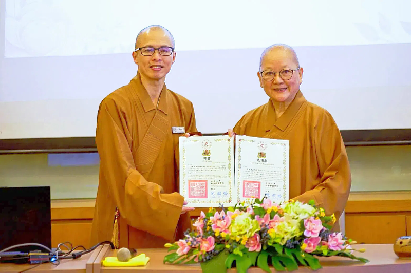 南華大學終身學院新加坡首開課，委辦單位新加坡佛光山住持妙穆法師(右)致贈聘書及感謝狀予釋知賢院長(左)。