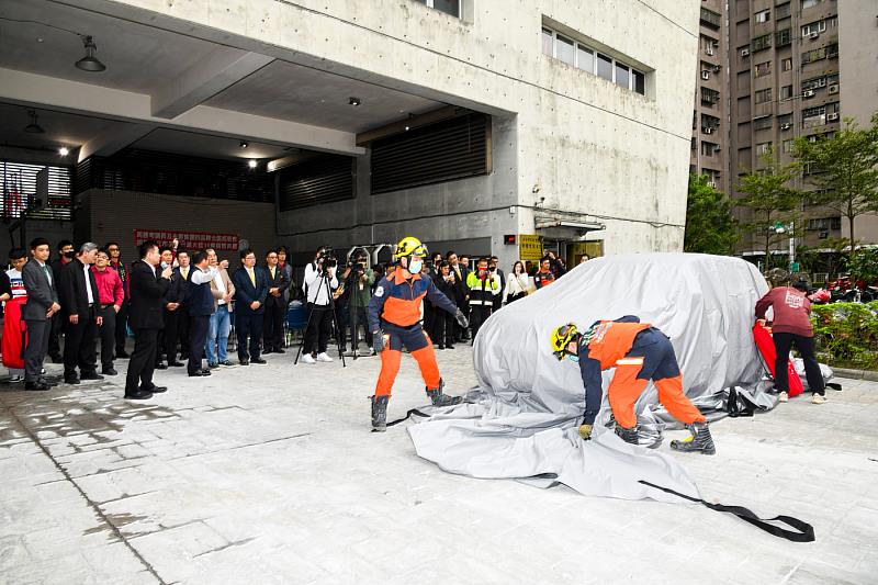 在捐贈現場中，消防人員親自示範如何用滅火毯快速撲滅電動車起火，讓災害降到最低點(永慶房產集團提供)