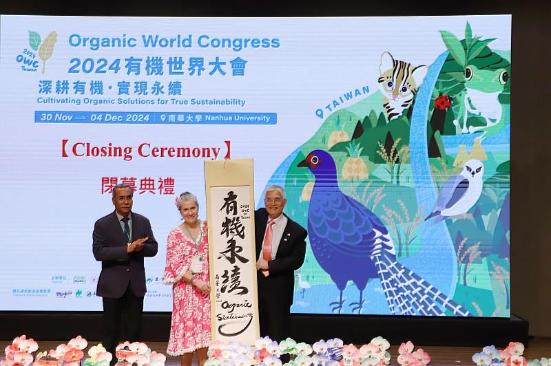 南華大學連續九年榮登世界百大綠色大學,圖為南華大學成功辦理「2024有機世界大會」,高俊雄校長(右)致贈親筆書寫的墨寶予IFOAM Organics International 主席 Karen Mapusua(中)。