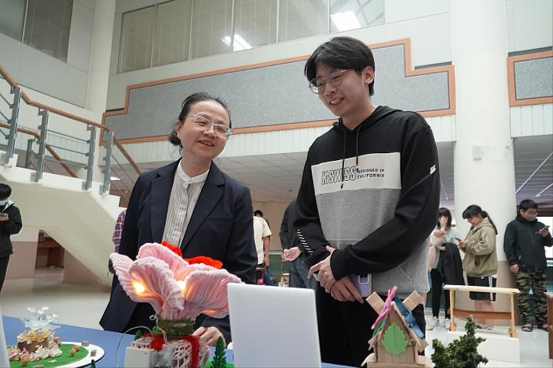 圖／國際人文社會暨智慧商務學院簡曉花院長（左），透過學生介紹了解作品。