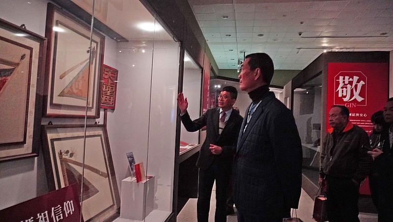 何金樑主任帶領與會貴賓參觀「拼.靚:臺灣客家多重面貌」客家文物聯展,觀賞北港朝天宮借出展示的進香旗等文物