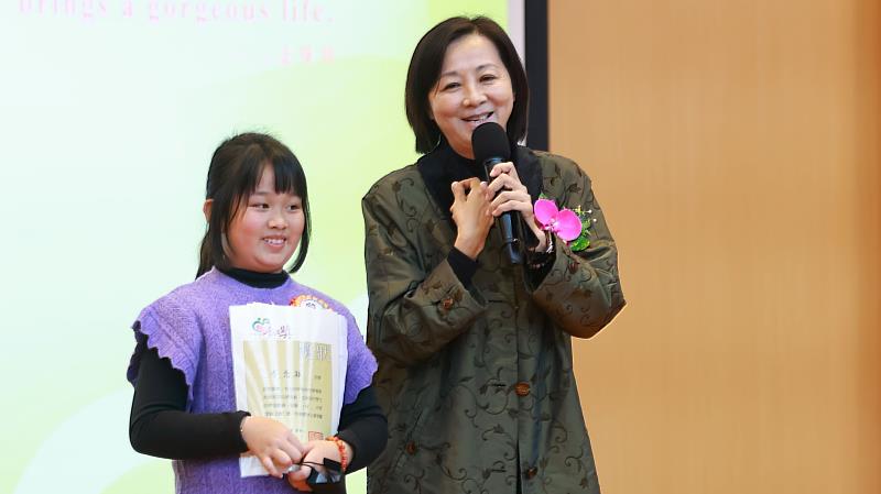圖說5. 小太陽念穎與校長一起上台,校長稱讚念穎孝順又懂事。 (圖片提供/靈鷲山佛教教團)