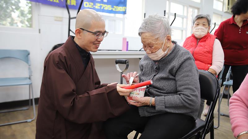 圖5：高齡102歲的老菩薩拿著臘八粥與心道師父新春墨寶，喜笑顏開。（靈鷲山佛教教團提供）