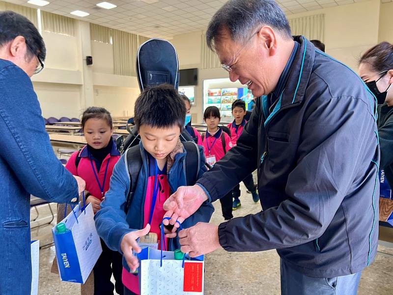 臺鹽董事長丁彥哲(右)贈送華山國小學童台塩生技牙膏、維他命C等禮物，祝福小朋友健康成長。