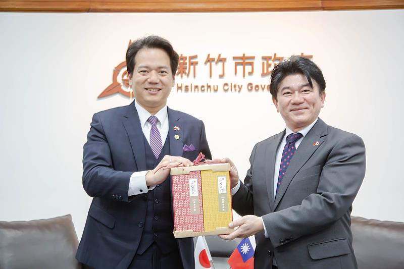 圖3:邱代理市長贈送竹市特色玻璃藝品「一柿蘋安」及米粉禮盒,安部徹也町長也回贈日出町當地名產城下鰈魚的陶器、日本第知名酒廠二階堂所釀燒酒及招福熊手禮品表達感謝之意。