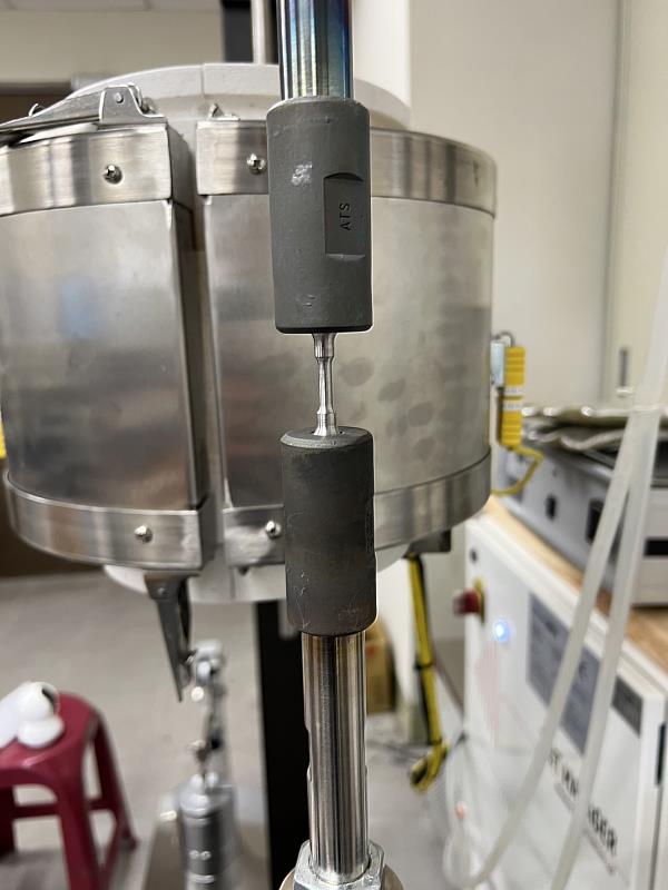 成大材料系特聘教授洪飛義團隊建立全國少數可以評估金屬氫脆的實驗室,實驗室內全台唯一的電動式高溫拉伸疲勞試驗機正進行氫脆測試
