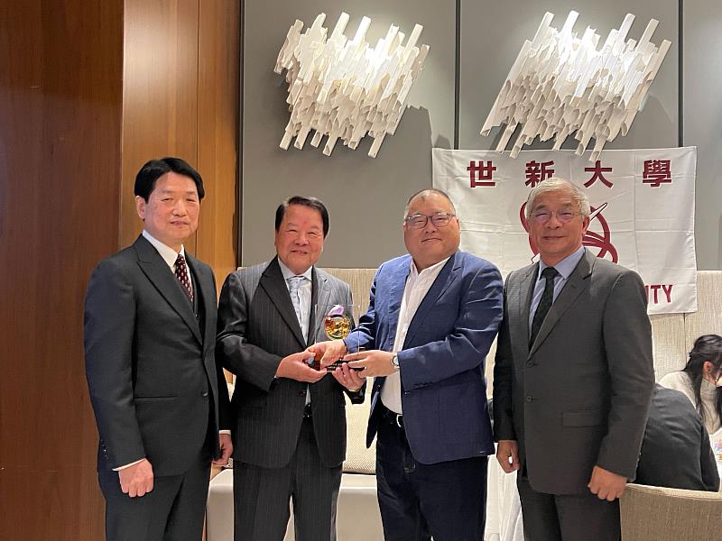 世新大學董事長周成虎（右二）與校長陳清河（右一）致贈日本校友會成立紀念牌，由籌備會長詹德薰（左二）與創會會長賴本勉（左一）代表接受，象徵校友會的正式啟動。（世新大學提供）