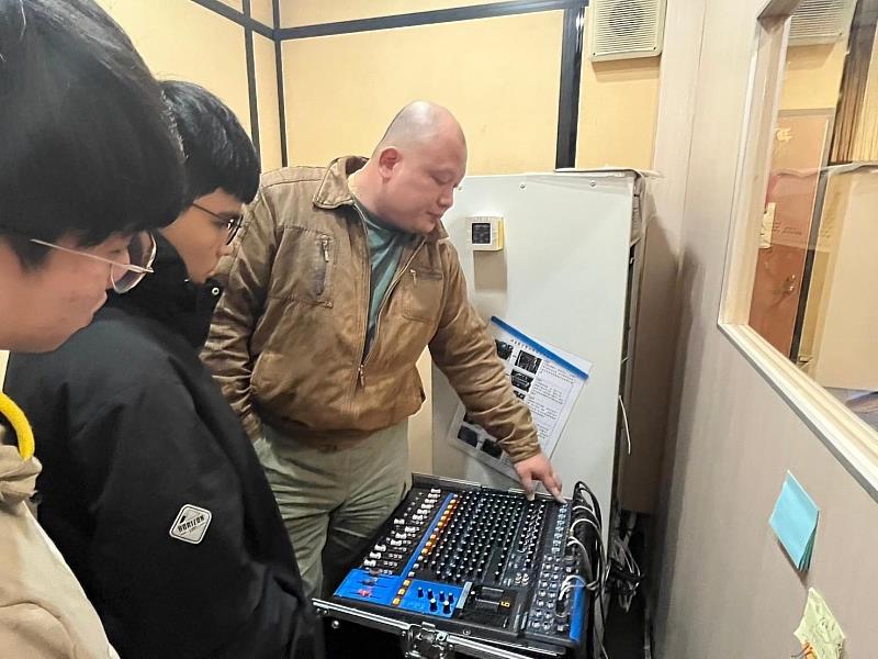 施宗育工程師(右)指導學生動手操作混音機,學習音訊輸入調整。