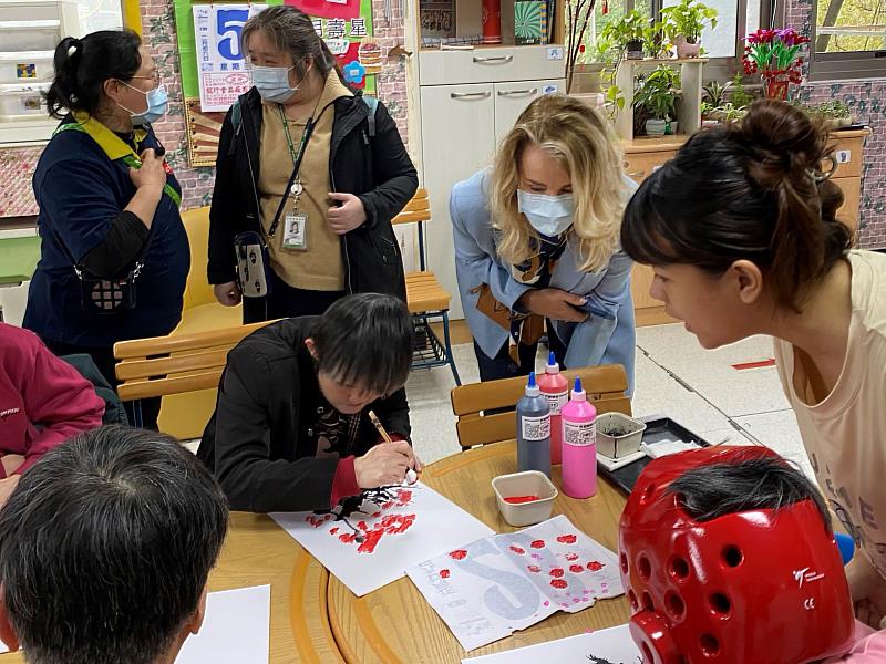 梵志登夫人(右二)前往桃園心燈啟智教養院，探視身心障礙高齡學員如何在老師(右一)的教導下展現繪畫天賦。