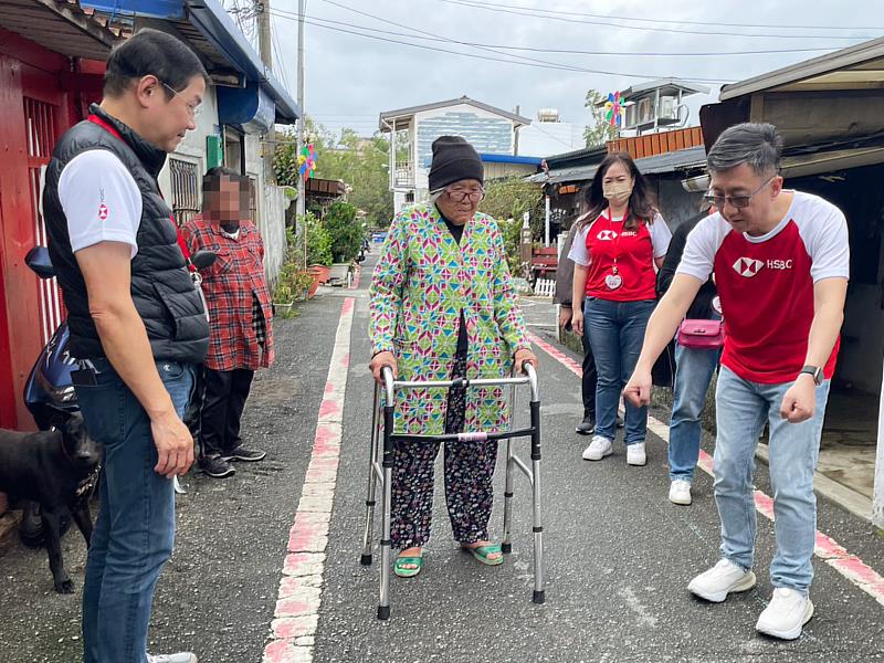 滙豐(台灣)商業銀行總經理暨環球銀行業務主管陳志堅(右)與愛心志工們為93歲的林婆婆送上合適輔具