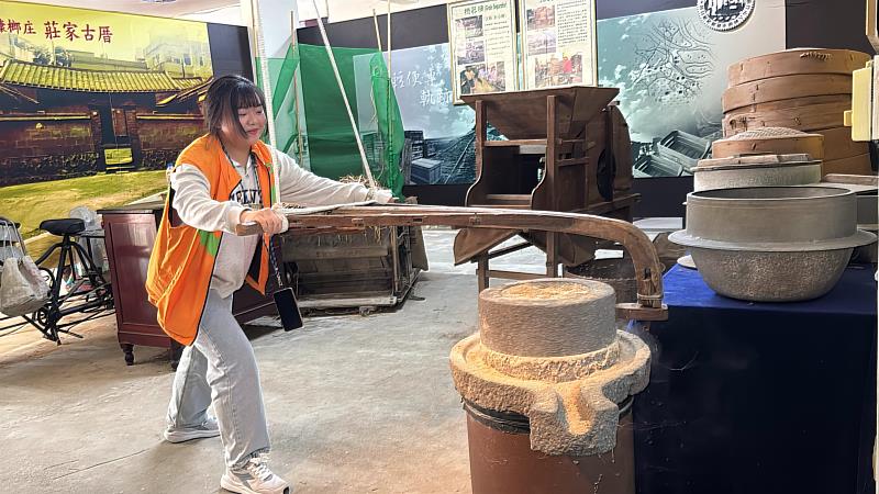 走讀活動中,青年節籌備委員體驗古代石磨並了解其用途
