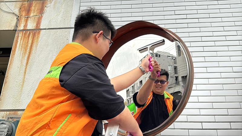 青年節籌備委員們認真擦拭著每面反射鏡,讓用路人更安全