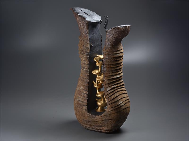 《所在 - 物件離合—許旭倫陶藝創作展》展覽主視覺作品在裂變與重組之間探尋形體的可能性。圖中作品猶如歷經風霜的器皿,內部卻蘊藏金色結構,彷彿時間雕琢出的生命核心。在破與立的對比中,藝術家詰問物件與存在的本質,引領觀者進入詩意與哲思交織的境地。