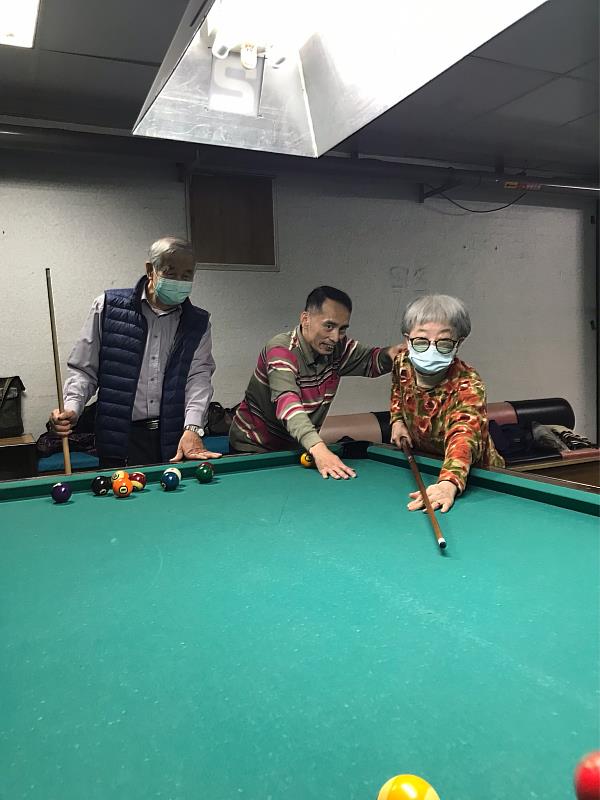 夏揮凱(中)指導長者撞球技巧