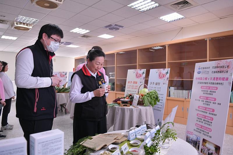 中醫預防醫學中心副主任陳中奎醫師(左)為徐榛蔚縣長解說養生茶飲如綠意養肝茶、慈濟福慧纖體茶及淨斯本草系列等相關藥材。