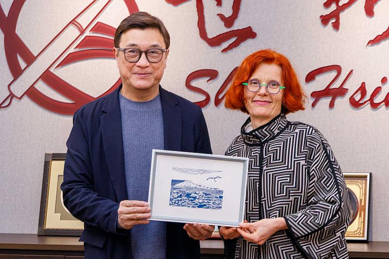 英國薩塞克斯大學國際發展副主任莫妮卡·梅蒂科娃（右）致贈象徵英國南部經典地標白堊斷崖的畫作，象徵兩校合作情誼。（世新大學提供）