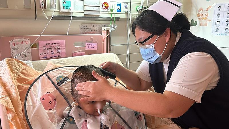 李依蓉投入兒科護理二十餘年,總是貼心的為病童著想。圖為李依蓉護理長幫腦傷病童理髮