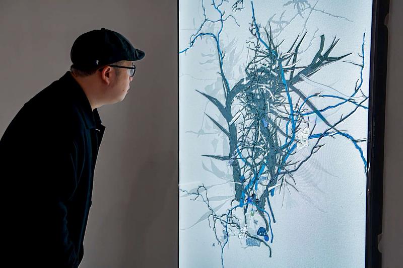 新竹241藝術空間「數位迷蹤」展覽-藝術家王新仁與其作品《合成植物學：後自然的分叉》合影。