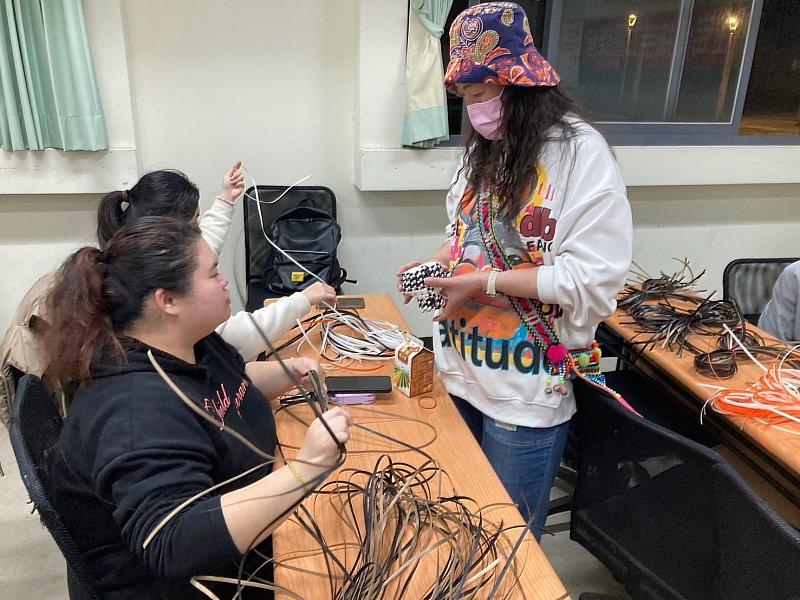 潘美蘭老師拿著成品與同學們說明編織過程中比較困難的細節。