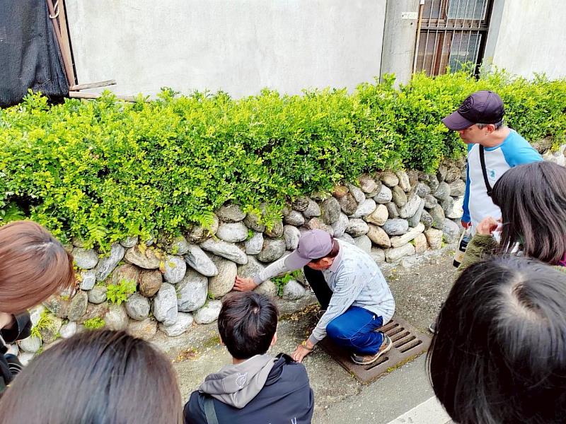 走進南華社區,在地技藝傳承者林先朝大哥親自帶領學生,學習砌石與茅草屋文化。