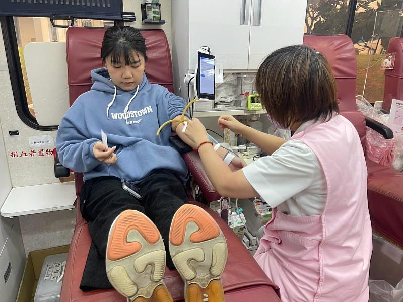學校職員捲起袖子捐血，為公益活動獻上愛心。