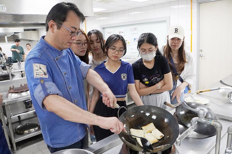 大葉大學餐旅系林言叡老師(左一)向國際學生講解煎蘿蔔糕的技巧