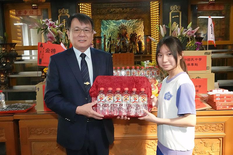 臺鹽公司董事長丁彥哲(左)贈與到開基玉皇宮拜拜的考生們「台塩金榜題名水」,祝福同學們會考順利、金榜題名。