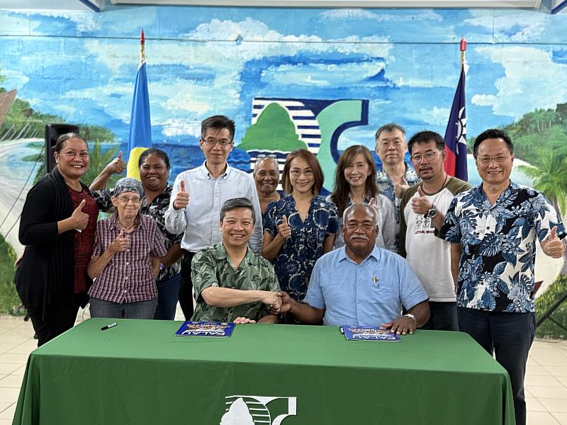 天主教輔仁大學藍易振校長(前左1)與帛琉社區大學校長Dr. Patrick U. Tellei(前右1)簽署合作備忘錄，駐帛琉大使黎倩儀(後中)、中華長照暨偏鄉醫療基金會王舜睦副董事長(後右3)、中華長照暨偏鄉醫療基金會陳常務董事愷翔(後右2)、輔仁大學林國際教育長耀南(後左4)及天主教輔仁大學醫學院林副院長瑜雯(後右4)見證及帛琉社區大學教職員見證。