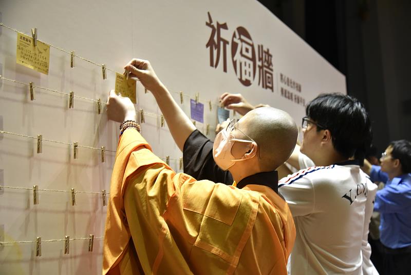 與會貴賓與僑生同學們將祈福卡掛上祈福牆